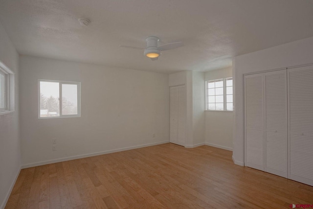 511 E Garland St, La Veta, CO 81055 - unfurnished bedroom featuring light wood-style flooring, baseboards, multiple closets, and a ceiling fan