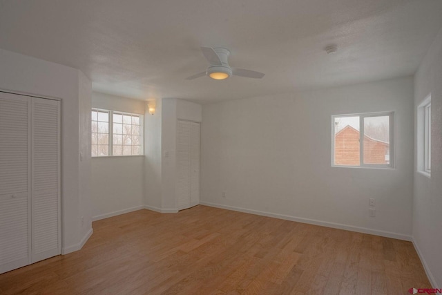 511 E Garland St, La Veta, CO 81055 - unfurnished bedroom with light wood-type flooring, multiple closets, baseboards, and a ceiling fan