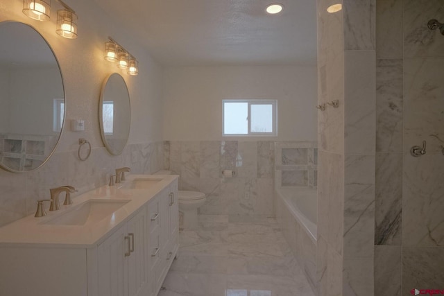 511 E Garland St, La Veta, CO 81055 - bathroom with a garden tub, tile walls, double vanity, toilet, and marble finish flooring