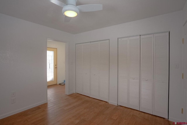 511 E Garland St, La Veta, CO 81055 - unfurnished bedroom with two closets, wood finished floors, baseboards, and a ceiling fan