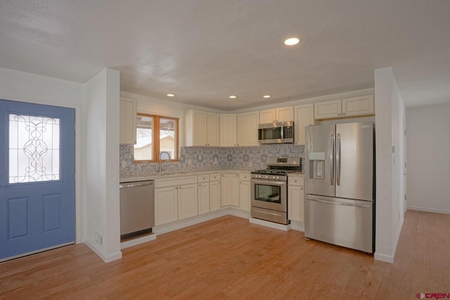 511 E Garland St, La Veta, CO 81055 - kitchen with appliances with stainless steel finishes, a sink, light countertops, tasteful backsplash, and light wood-type flooring