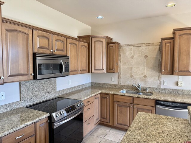 1252 Peppertree Dr, Montrose, CO 81401 - kitchen with appliances with stainless steel finishes, a sink, light tile patterned floors, light stone counters, and brown cabinets