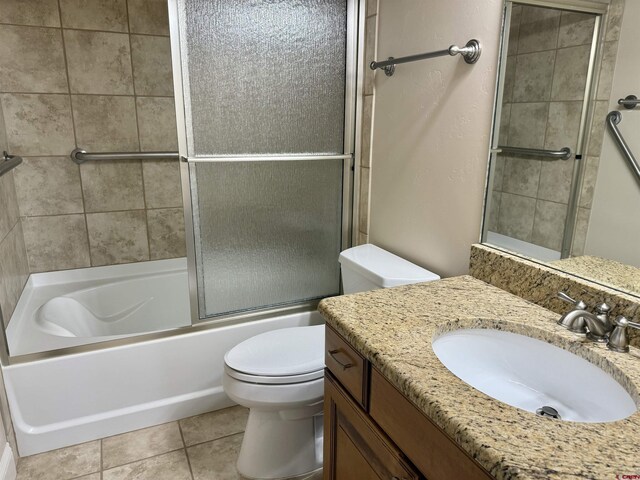 1252 Peppertree Dr, Montrose, CO 81401 - bathroom featuring toilet, vanity, tile patterned flooring, and combined bath / shower with glass door