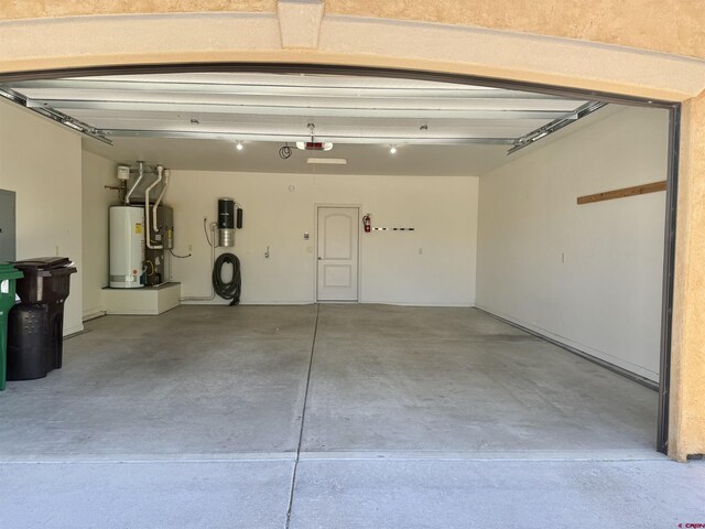 1252 Peppertree Dr, Montrose, CO 81401 - garage featuring gas water heater, a central vacuum unit, and a garage door opener