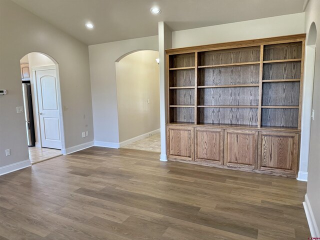 1252 Peppertree Dr, Montrose, CO 81401 - spare room featuring arched walkways, wood finished floors, baseboards, and recessed lighting