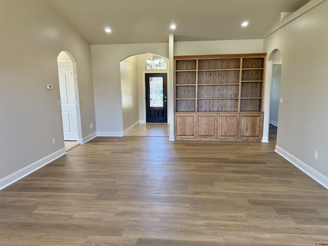 1252 Peppertree Dr, Montrose, CO 81401 - spare room featuring arched walkways, baseboards, recessed lighting, and wood finished floors