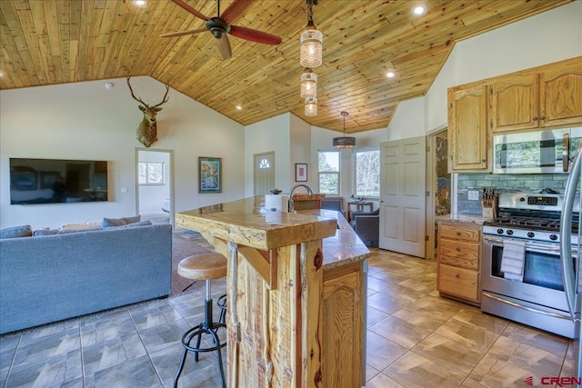 49 Sugarloaf Dr, Pagosa Springs, CO 81147 - kitchen featuring appliances with stainless steel finishes, a kitchen island with sink, wood ceiling, a ceiling fan, and decorative light fixtures