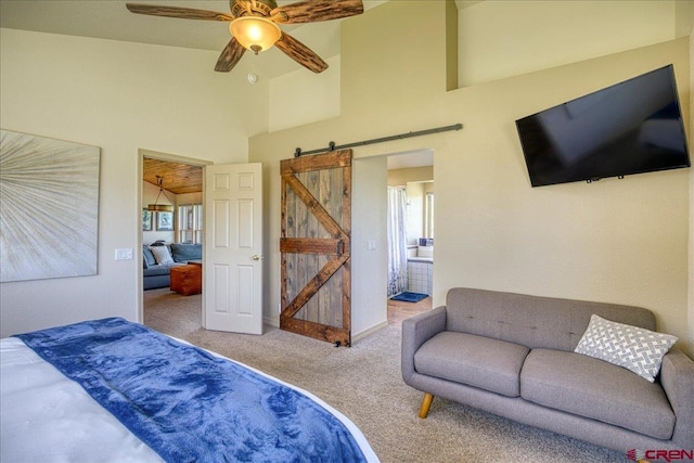 49 Sugarloaf Dr, Pagosa Springs, CO 81147 - bedroom featuring a barn door, carpet flooring, multiple windows, high vaulted ceiling, and ensuite bath