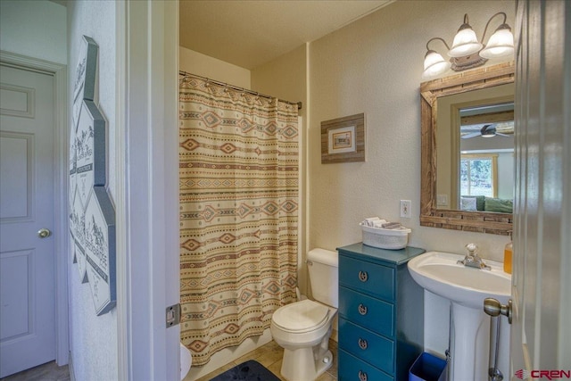49 Sugarloaf Dr, Pagosa Springs, CO 81147 - bathroom with toilet, a ceiling fan, a textured wall, curtained shower, and a sink
