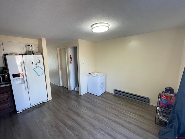 516 N 14th St Unit A, Gunnison, CO 81230 - kitchen with white refrigerator with ice dispenser, baseboard heating, dark wood-style flooring, stainless steel microwave, and a textured ceiling