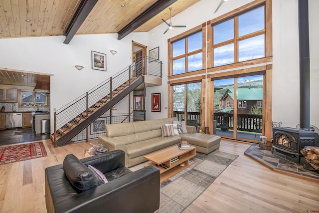 190 Teocalli Rd, Crested Butte, CO 81224 - living room featuring a ceiling fan, a wood stove, high vaulted ceiling, wood finished floors, and wooden ceiling with exposed beams