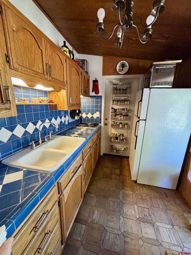 1615 Maple Ct, Grand Junction, CO 81505 - kitchen with freestanding refrigerator, tile countertops, a sink, brown cabinetry, and backsplash