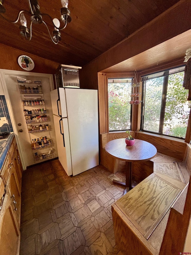 1615 Maple Ct, Grand Junction, CO 81505 - kitchen with freestanding refrigerator, wooden ceiling, dark flooring, a chandelier, and dark countertops