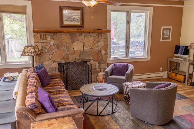 51 Blake St, Placerville, CO 81430 - living room with a baseboard radiator, wood finished floors, plenty of natural light, and a stone fireplace