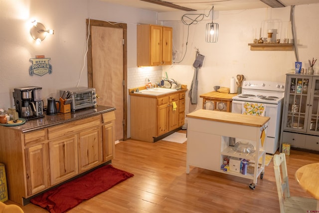 51 Blake St, Placerville, CO 81430 - kitchen with white range with electric cooktop, open shelves, light wood finished floors, backsplash, and a sink