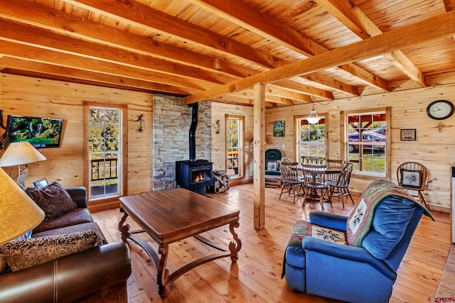LOT7 Aspen Hills Rd, Cedaredge, CO 81413 - living area with a wood stove, wood ceiling with exposed beams, wooden walls, light wood-type flooring, and healthy amount of natural light