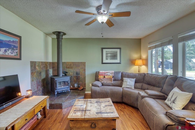 43 W Radiant Ct, Pagosa Springs, CO 81147 - living area with a textured ceiling, a wood stove, ceiling fan, and wood finished floors