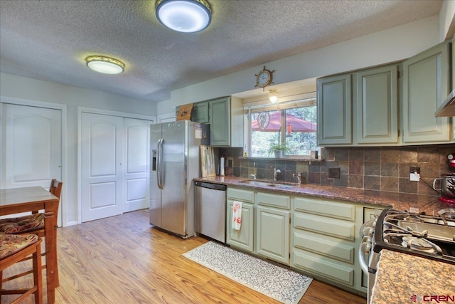 43 W Radiant Ct, Pagosa Springs, CO 81147 - kitchen featuring appliances with stainless steel finishes, green cabinetry, a textured ceiling, light wood-style flooring, and a sink