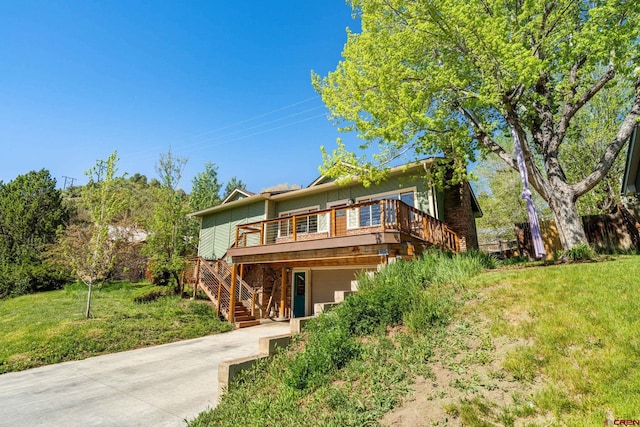 2503 Borrego Dr, Durango, CO 81301 - view of front of home with a wooden deck, stairs, a front yard, concrete driveway, and an attached garage