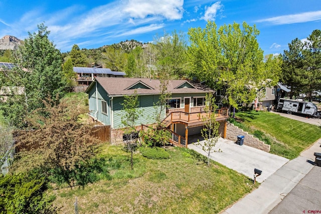 2503 Borrego Dr, Durango, CO 81301 - ranch-style home with concrete driveway, a wooden deck, a front lawn, and an attached garage
