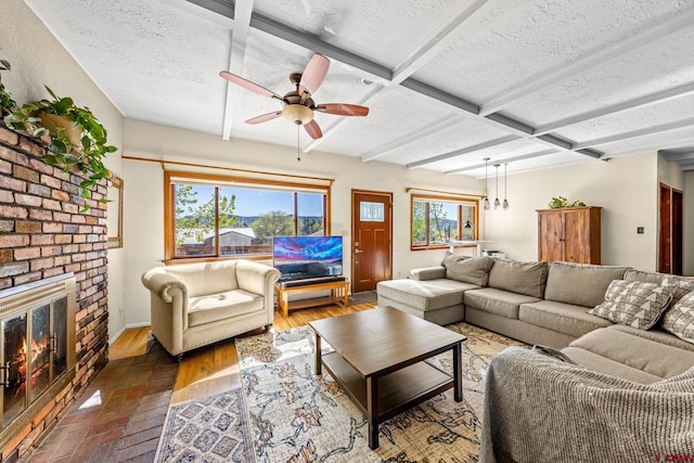 2503 Borrego Dr, Durango, CO 81301 - living room featuring a textured ceiling, a fireplace, a ceiling fan, beam ceiling, and baseboards