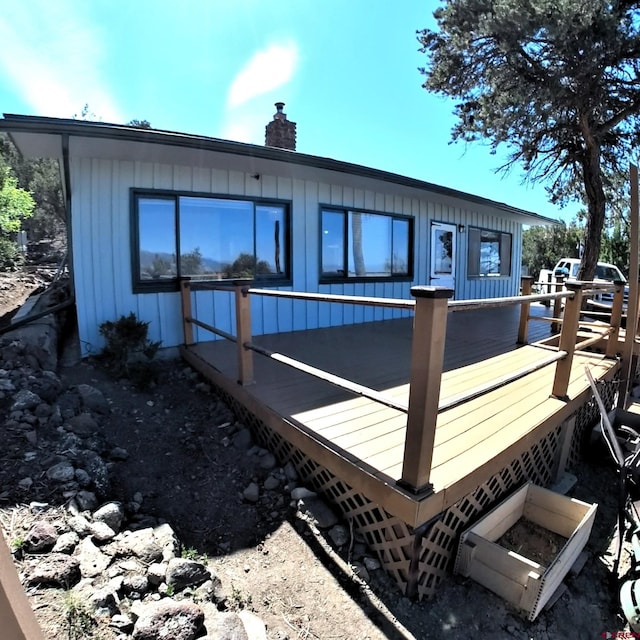 17992 Hanson Rd, Cedaredge, CO 81413 - rear view of house featuring a wooden deck, a chimney, and board and batten siding