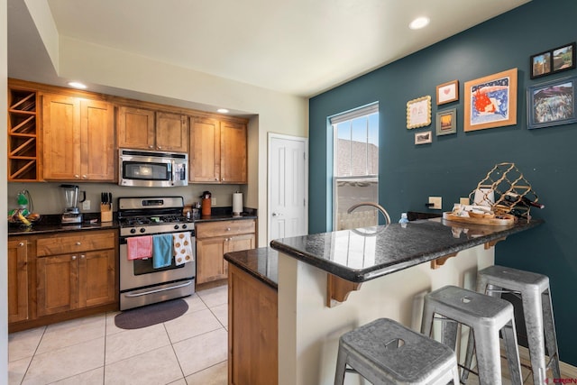 236 Sierra Vista St, Durango, CO 81301 - kitchen featuring stainless steel appliances, a breakfast bar, brown cabinetry, open shelves, and light tile patterned floors