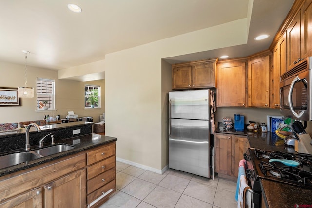 236 Sierra Vista St, Durango, CO 81301 - kitchen featuring stainless steel appliances, a sink, brown cabinets, light tile patterned floors, and dark stone counters
