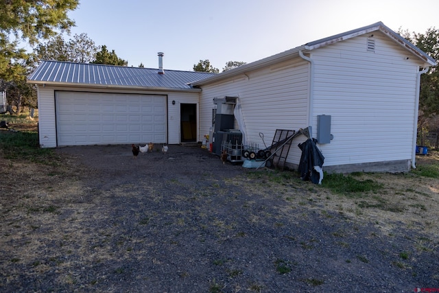13569 3100th Rd, Hotchkiss, CO 81419 - back of property with a garage, metal roof, cooling unit, and driveway