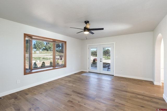 41 Ridge Pl, Durango, CO 81301 - unfurnished room featuring arched walkways, wood finished floors, french doors, a ceiling fan, and baseboards