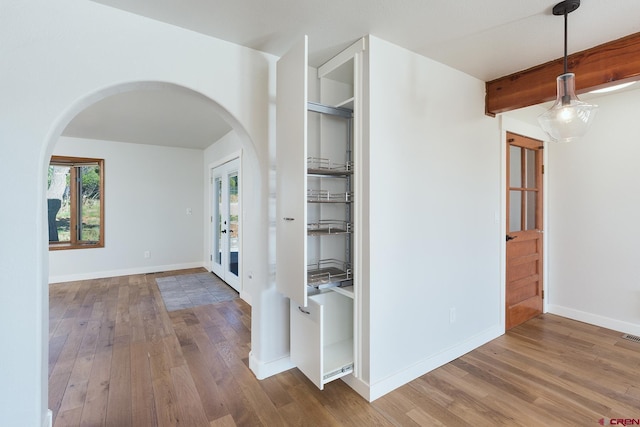 41 Ridge Pl, Durango, CO 81301 - hallway featuring arched walkways, wood finished floors, french doors, and beam ceiling