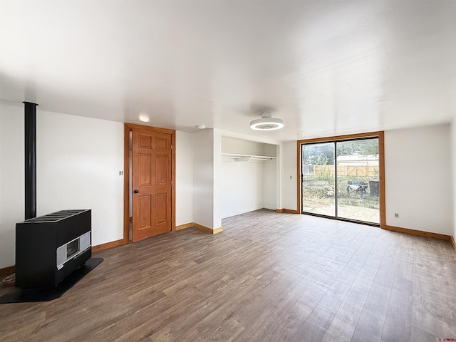 1246 Meeker St, Delta, CO 81416 - unfurnished living room with baseboards, wood finished floors, a wood stove, and heating unit