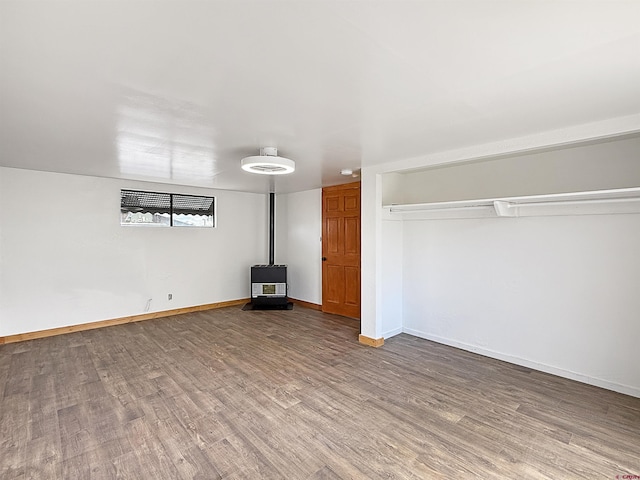 1246 Meeker St, Delta, CO 81416 - unfurnished living room with a wood stove, wood finished floors, and baseboards