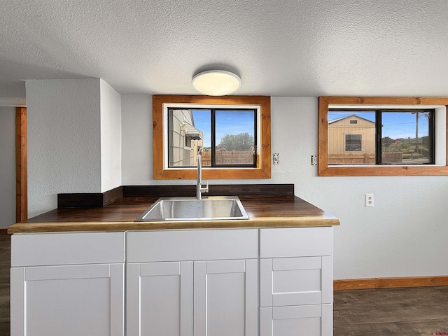 1246 Meeker St, Delta, CO 81416 - kitchen with a sink, dark countertops, a textured ceiling, baseboards, and dark wood-style floors