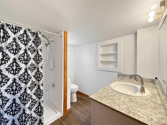 1246 Meeker St, Delta, CO 81416 - bathroom with vanity, wood finished floors, a stall shower, toilet, and built in shelves