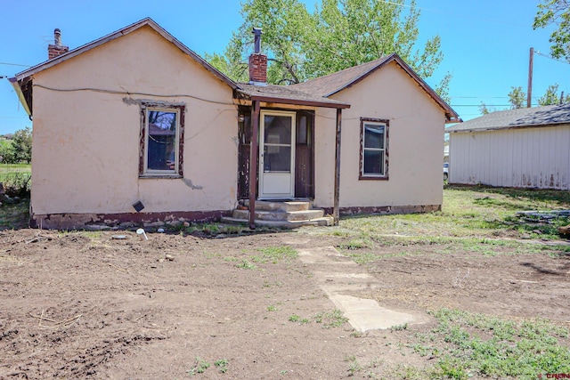 327/327.5 E 7th St, Walsenburg, CO 81089 - view of front facade with a chimney and stucco siding