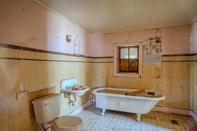 327/327.5 E 7th St, Walsenburg, CO 81089 - bathroom featuring tile walls, a soaking tub, crown molding, toilet, and a wainscoted wall