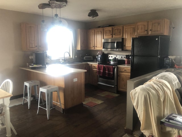 22 Lancer Ct, Pagosa Springs, CO 81147 - kitchen featuring stainless steel appliances, a peninsula, dark wood-style floors, a sink, and light countertops