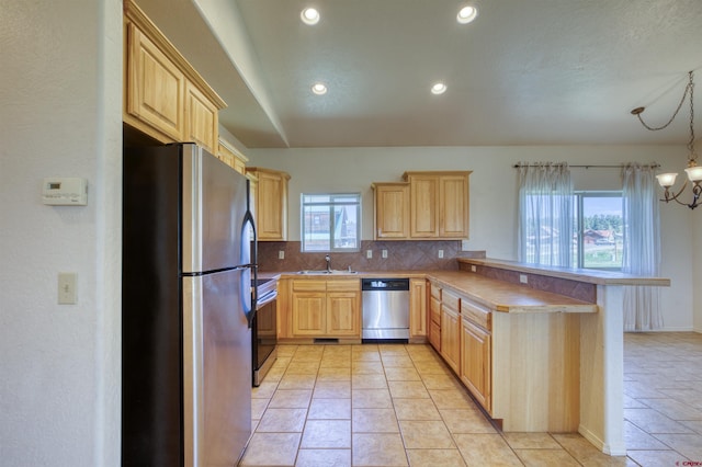 2038 Park Ave, Pagosa Springs, CO 81147 - kitchen with appliances with stainless steel finishes, light brown cabinetry, a sink, a peninsula, and recessed lighting