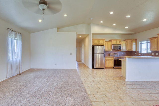 2038 Park Ave, Pagosa Springs, CO 81147 - kitchen with stainless steel appliances, vaulted ceiling, ceiling fan, decorative backsplash, and recessed lighting