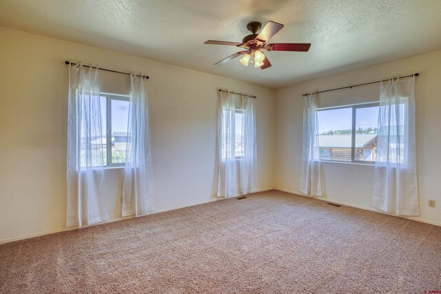 2038 Park Ave, Pagosa Springs, CO 81147 - carpeted spare room featuring healthy amount of natural light, a ceiling fan, a textured ceiling, and baseboards