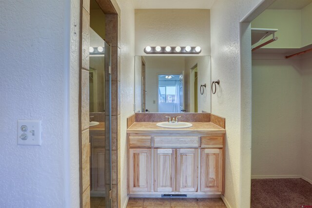 2038 Park Ave, Pagosa Springs, CO 81147 - bathroom with a textured wall, vanity, a stall shower, and baseboards