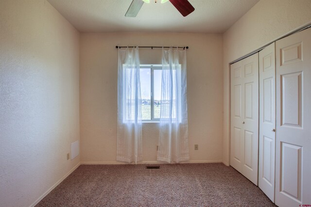 2038 Park Ave, Pagosa Springs, CO 81147 - unfurnished bedroom with carpet, a closet, baseboards, and a ceiling fan