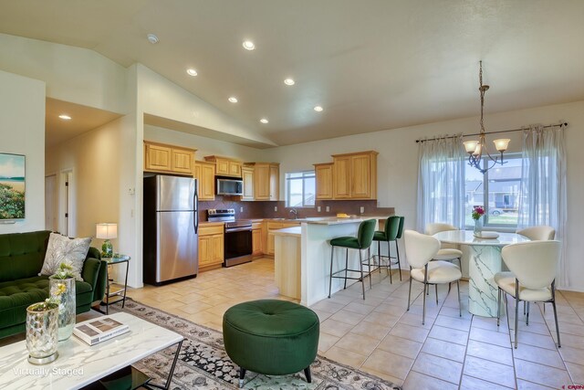 2038 Park Ave, Pagosa Springs, CO 81147 - kitchen with stainless steel appliances, lofted ceiling, recessed lighting, a peninsula, and decorative backsplash