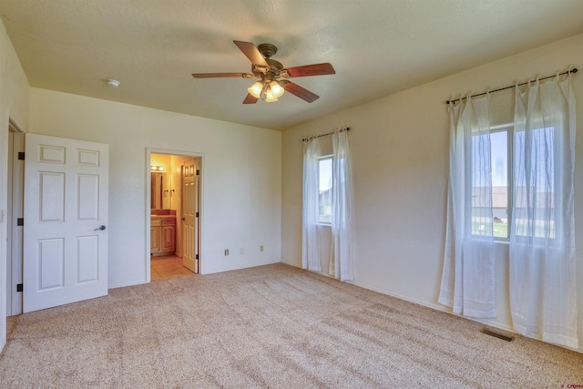 2038 Park Ave, Pagosa Springs, CO 81147 - unfurnished bedroom featuring light carpet, connected bathroom, ceiling fan, and baseboards