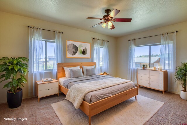 2038 Park Ave, Pagosa Springs, CO 81147 - bedroom featuring multiple windows, carpet floors, a textured ceiling, and ceiling fan