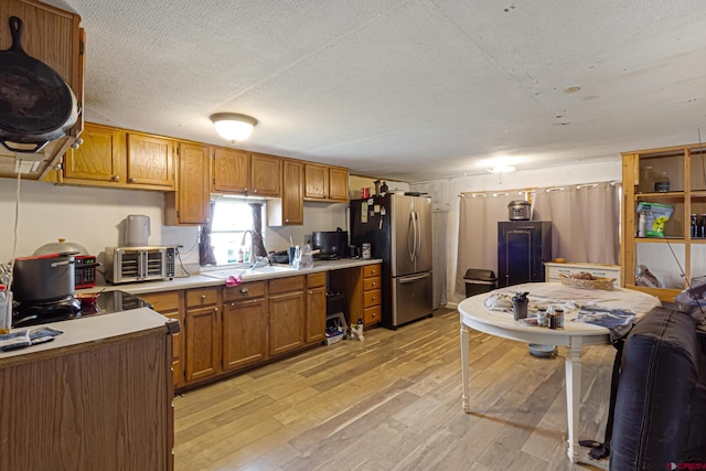 3268 E Rd Unit 1, Clifton, CO 81520 - kitchen featuring freestanding refrigerator, a sink, light wood-style flooring, light countertops, and brown cabinets