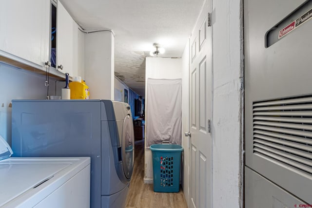 3268 E Rd Unit 1, Clifton, CO 81520 - laundry area featuring independent washer and dryer, cabinet space, a heating unit, light wood-type flooring, and a textured ceiling