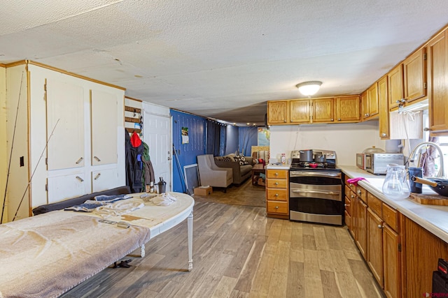 3268 E Rd Unit 1, Clifton, CO 81520 - kitchen with range with two ovens, light wood finished floors, light countertops, brown cabinetry, and a textured ceiling