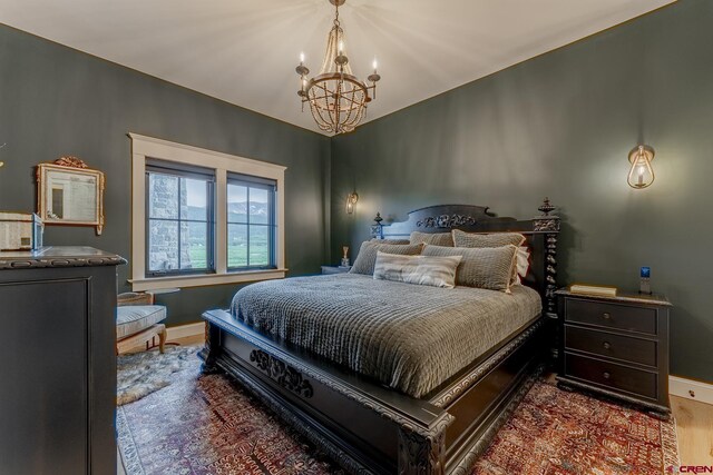 905 County Road 317, Crested Butte, CO 81224 - bedroom featuring a chandelier, wood finished floors, and baseboards
